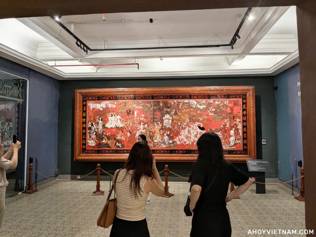 Visitors looking at a large painting inside the Ho Chi Minh City Museum of Fine Arts