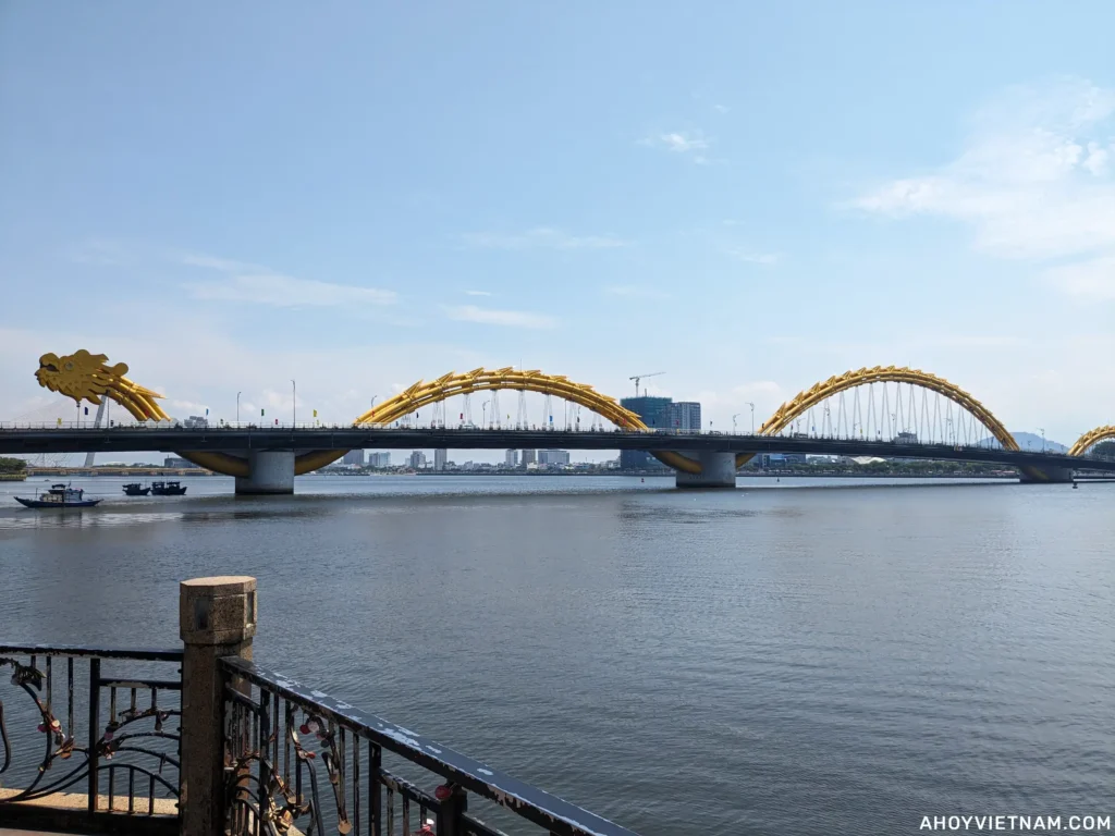 The yellow Dragon Bridge over the Han River in Da Nang, Vietnam, on a blue-skied day.