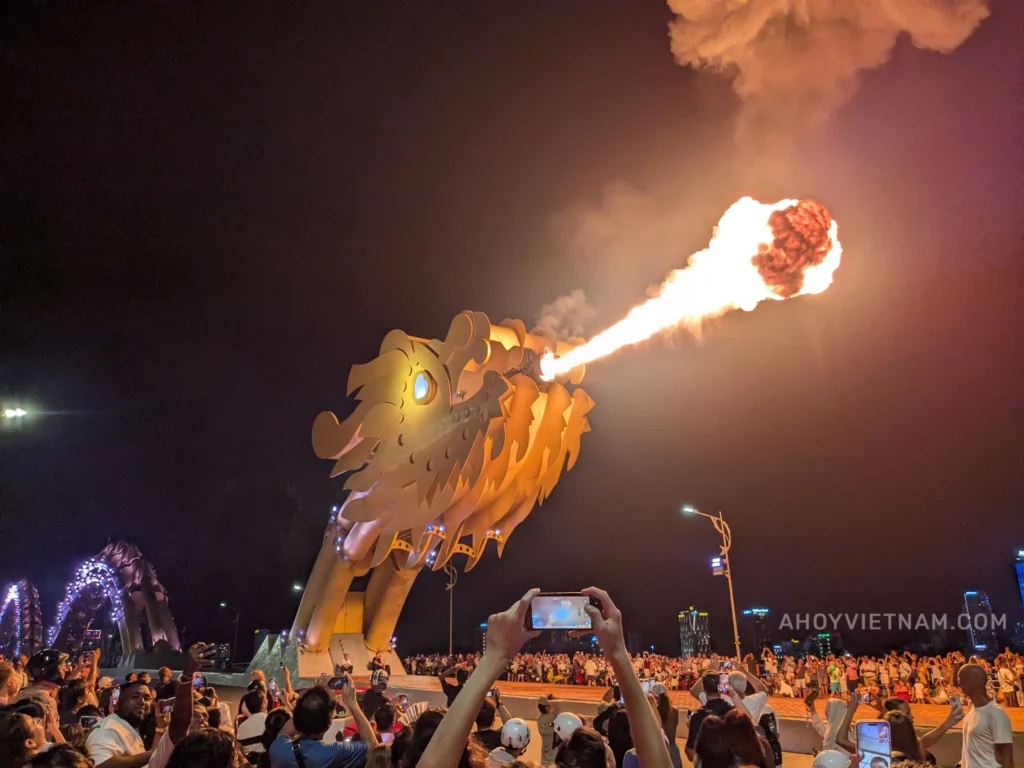 Da Nang's Dragon Bridge breathing fire, with hundreds of tourists gathered around