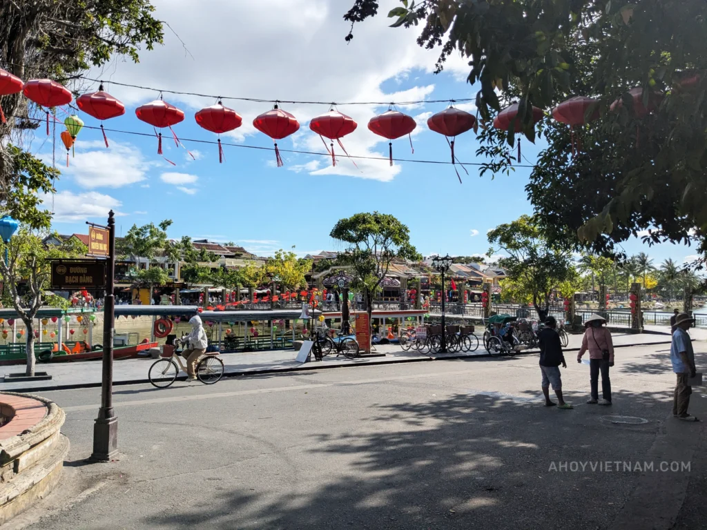 Hanging lanterns, locals, bicycles, and tourists in Hoi An Old Town