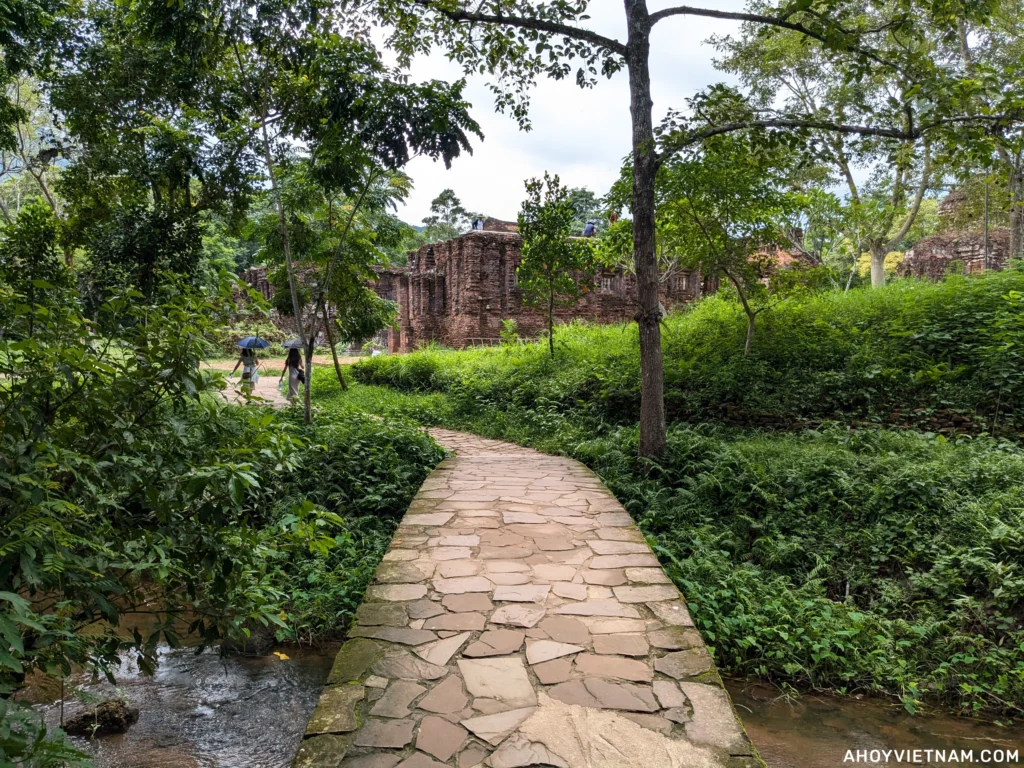 A cobblestone path over a creek leading to ruins at the My Son Sanctuary in Vietnam.