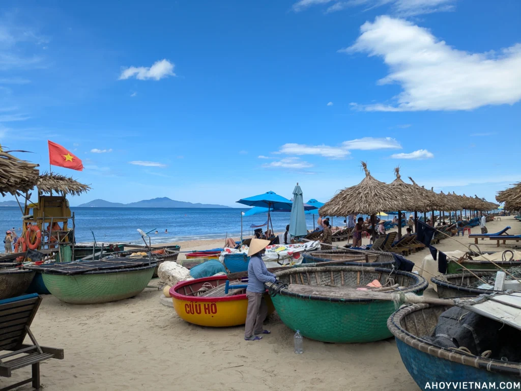 Basket boats and tourists on An Bang Beach in Hoi An in June.