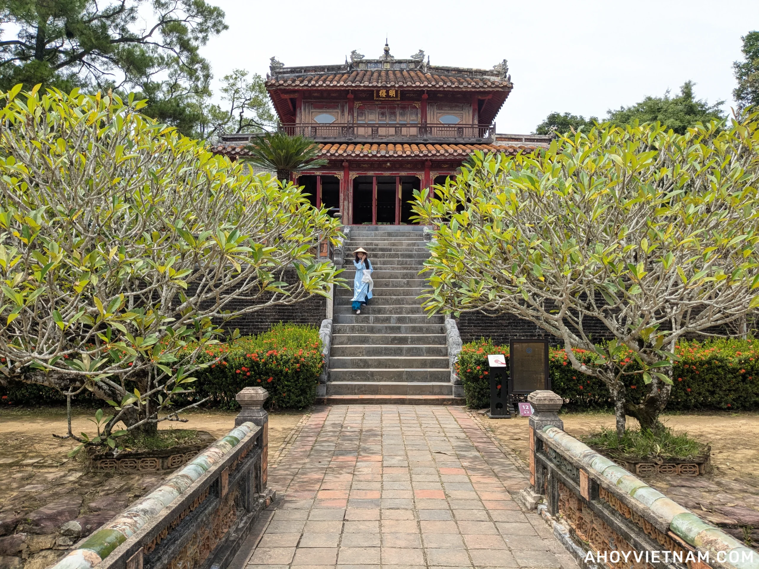 A local Vietnamese in a conical hat coming down the stairs of a building at Minh Mang's tomb in Hue, Vietnam