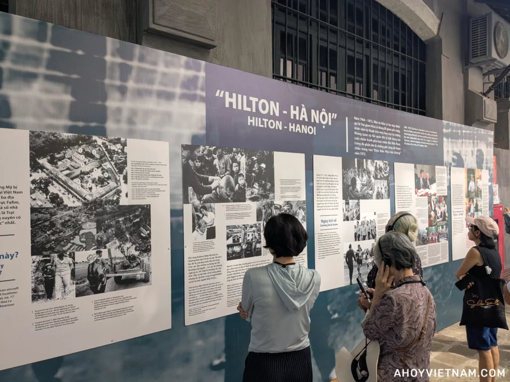 Visitors looking at the "Hanoi Hilton" display inside Hoa Lo Prison in Hanoi
