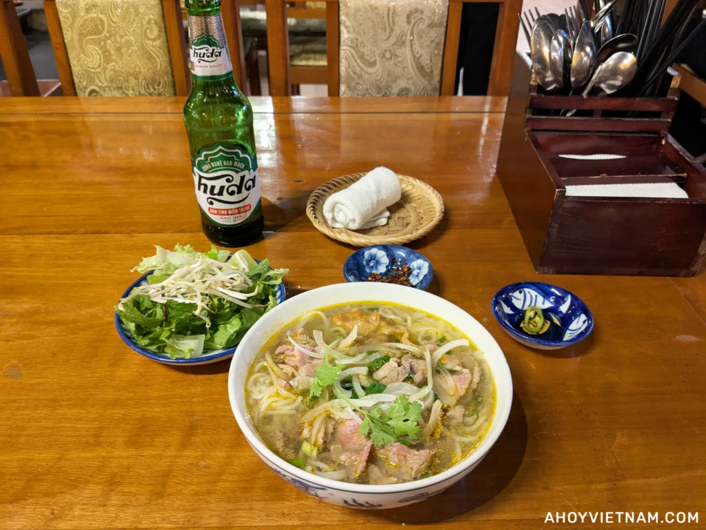 A bottle of Huda Beer and a bowl of bun bo Hue at Madam Thu Restaurant in Hue, Vietnam