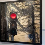 A painting by Vietnamese artist Nguyen Ngoc Dan showing a red stop light tangled with numerous electrical wires