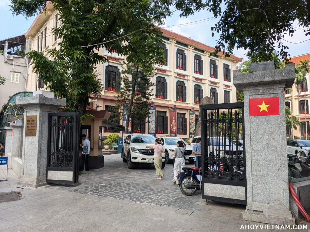 Visitors, parked cars, and scooters outside the entrance of the Vietnam National Fine Arts Museum in Hanoi, Vietnam