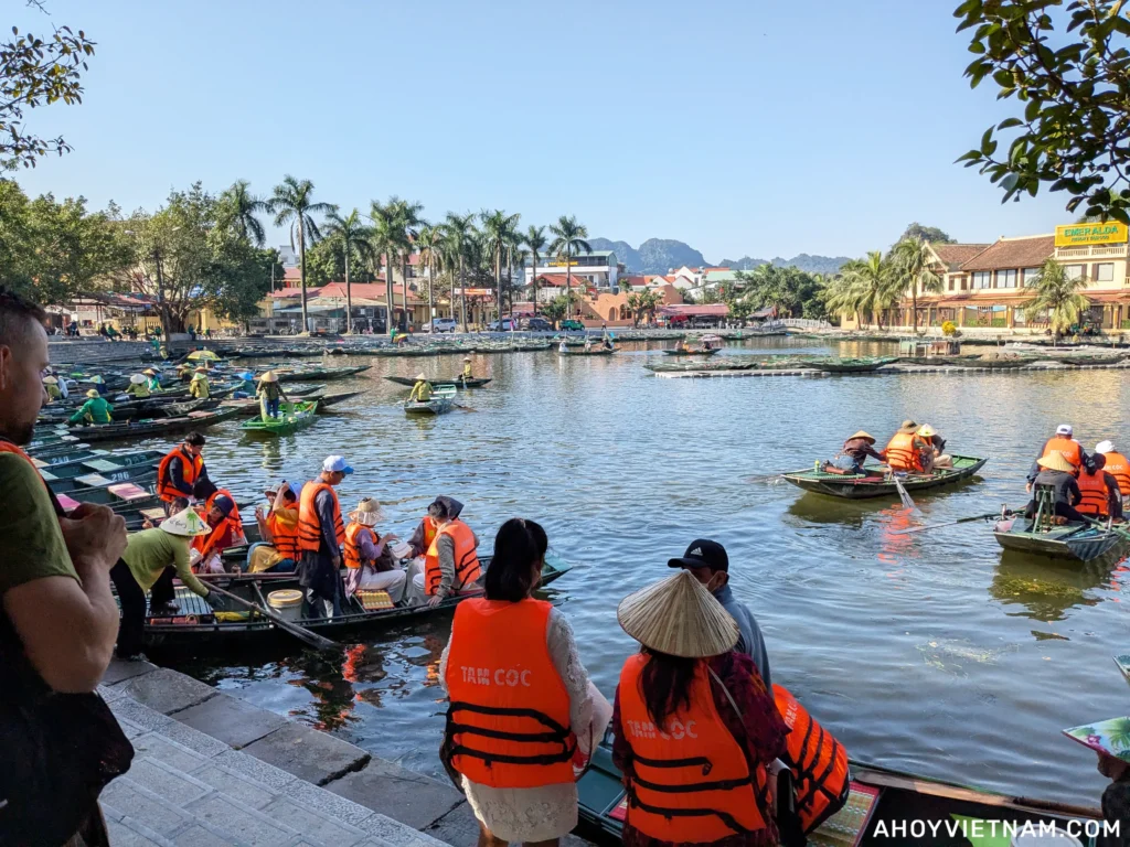 Travelers getting onto boats at the Tam Coc boat tour departure point in Ninh Binh, Vietnam