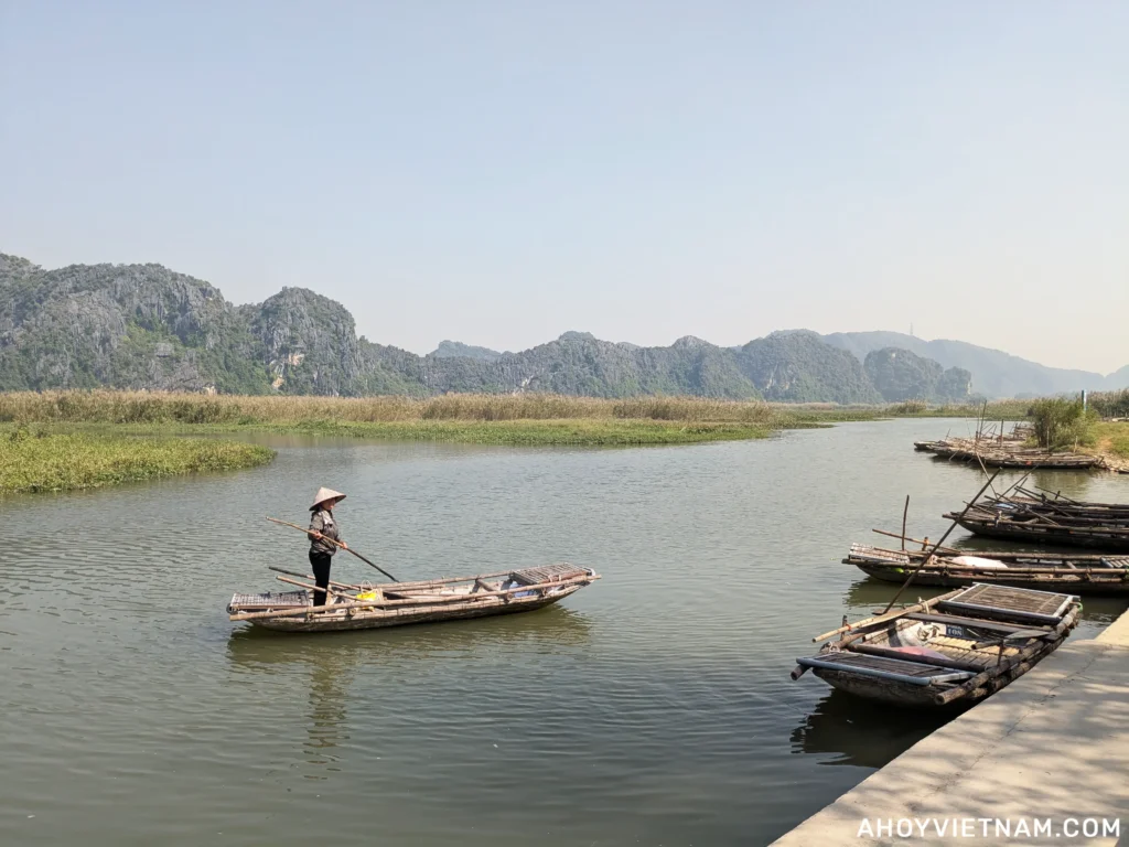 A local in a boat on the river at the Van Long Nature Reserve in Ninh Binh, Vietnam