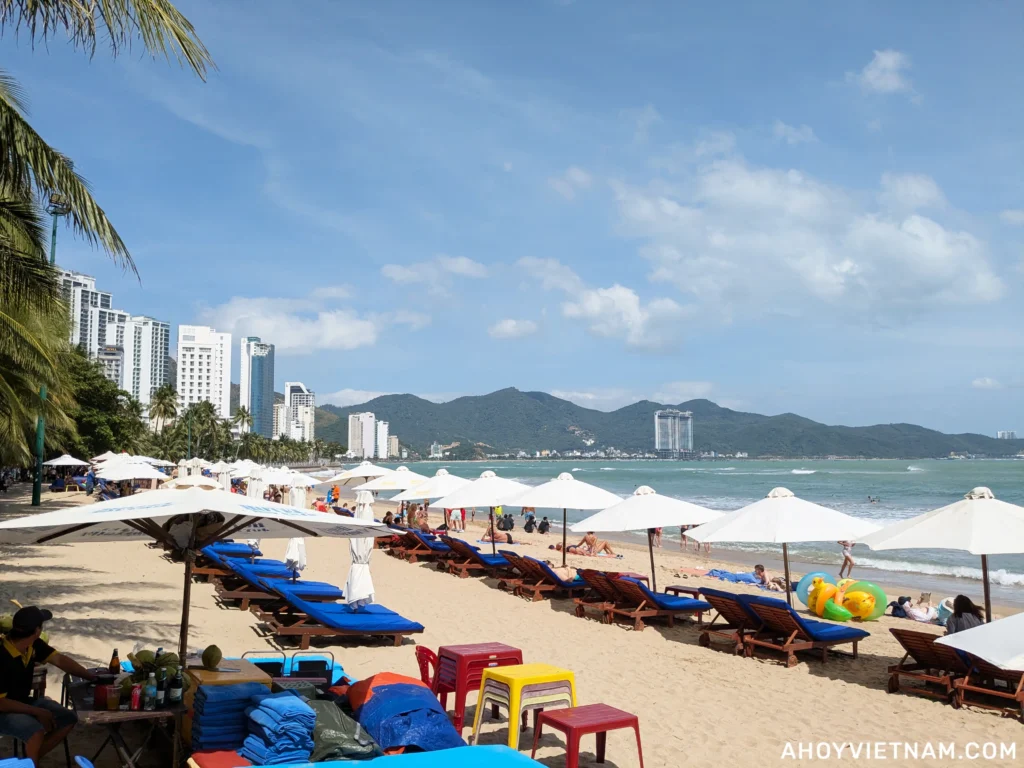 Sun loungers, umbrellas, and beachgoers on Hon Chong Beach in Nha Trang, Vietnam