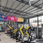 A lot of exercise machines and people training inside HealthFit Gym in Hoi An, Vietnam