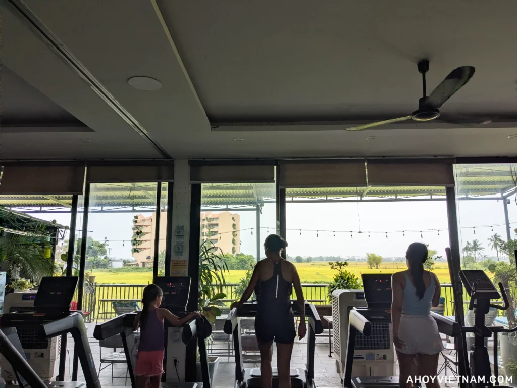 People on treadmills overlooking the rice fields at HealthFit Gym in Hoi An